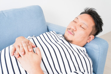 自宅で昼寝をする中年の男性
