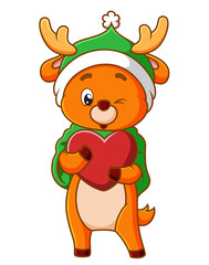 The cute deer is wearing the winter costume and holding the love