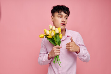 portrait of a young man bouquet of flowers date romance posing pink background unaltered