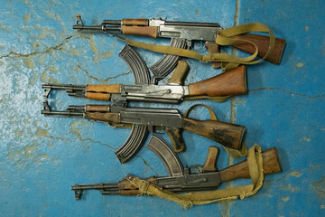 Old AK-47 machine guns on a concrete floor. Kalashnikov assault rifles. 7.62x39 ammo ak47.