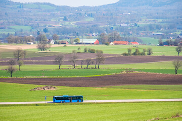 Fototapeta na wymiar Bus on a country road in a rural landscape