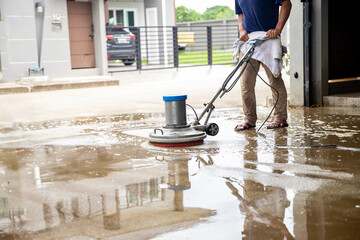 A Man worker cleaning the floor with scrubber machine.