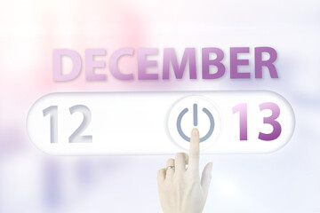 December 13rd. Day 13 of month, Calendar date.Hand finger switches pointing calendar date on sunlight office background. Winter month, day of the year concept.