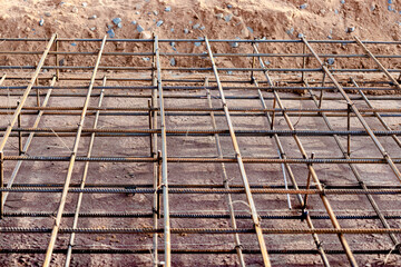 Spatial reinforcement of the floor and foundation with reinforcement. Preparing the foundation for pouring concrete. Industrial construction site.