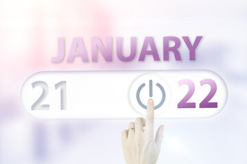 January 22nd. Day 22 of month, Calendar date.Hand finger switches pointing calendar date on sunlight office background. Winter month, day of the year concept.