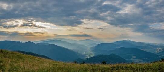 Summer evening in the mountains. Panorama of a mountain landscape in the Carpathians. View of the valley from the top of Mount Bozova