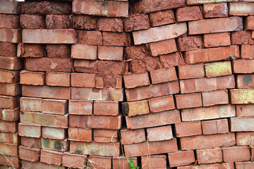 Fototapeta premium A red old brick stacked together under the open sky. Improper storage of bricks.Building materials