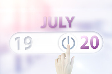 July 20th. Day 20 of month, Calendar date.Hand finger switches pointing calendar date on sunlight office background. Summer month, day of the year concept.