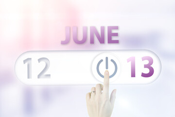 June 13rd. Day 13 of month, Calendar date.Hand finger switches pointing calendar date on sunlight office background. Summer month, day of the year concept.