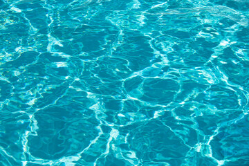 Background of blue water in swimming pool with sun reflection, ripple water wave in pool. Clear water background.