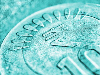 Translation: rupee. Fragment of Indian 10 rupee coin with the sign of the national currency close-up. Turquoise tinted background from money about economy or finances of India. Macro