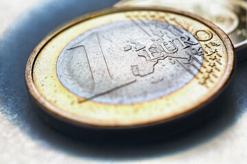 Euro coins. The focus is on the inscription with the name of the Euro Zone currency on the 1 euro coin. Closeup. Expressive illustration about the economy and money of the European Union. Macro