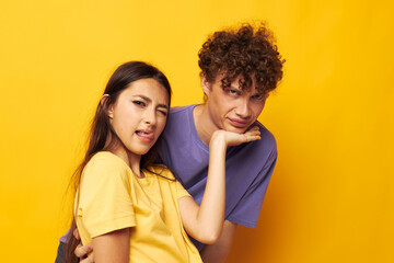 Fototapeta premium cute young couple in colorful t-shirts posing friendship fun isolated background unaltered