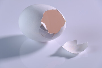 Ein offenes Ei - eine zerbrechliche leere Eierschale auf einem weißen neutralen Hintergrund