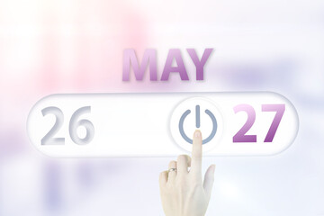 May 27th. Day 27 of month, Calendar date.Hand finger switches pointing calendar date on sunlight office background. Spring month, day of the year concept.