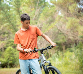 Obraz premium happy teen boy riding a bike on natural background, forest or park. healthy lifestyle, family day out
