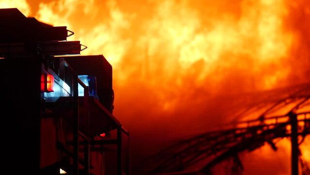fire truck and flasher fire engine. fire on the roof of the house. a burning at building night house. home apartment insurance concept. huge fire blazes houses 911. property damage arson protection