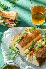 Sandwich with chicken, cucumber and arugula on a green background