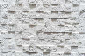 Fragment of a white wall made of decorative stone in a three-dimensional shape and square textured elements. flat lay frame