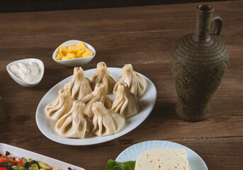 Georgian dumplings khinkali, wine, cheese, pickles and  salad,on the table.