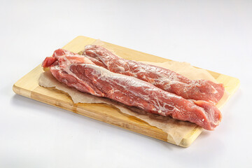 Raw pork tenderloin over board