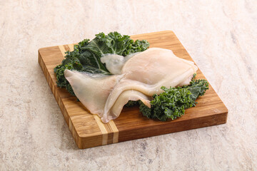 Raw squid over wooden board