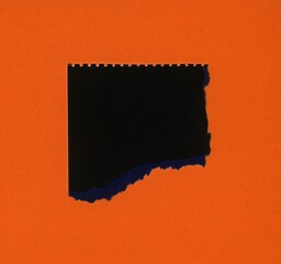 torn orange paper with black hole