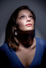 Studio portrait of young beautiful sensual woman in blue dress.