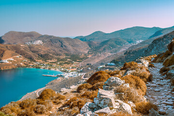 Wanderweg aus dem Hochland zur Bucht von Aegiali mit Hafen auf der griechischen Insel Amorgos - obrazy, fototapety, plakaty