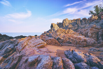 Obraz premium Beautiful beach with golden sand, rocks and blue sky.