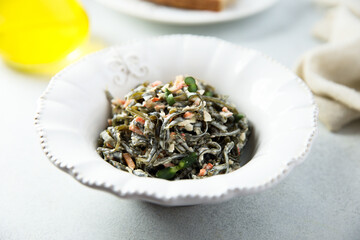 Fototapeta na wymiar Seaweed salad with vegetables and herbs