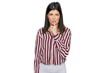 Beautiful brunette woman wearing striped shirt asking to be quiet with finger on lips. silence and secret concept.