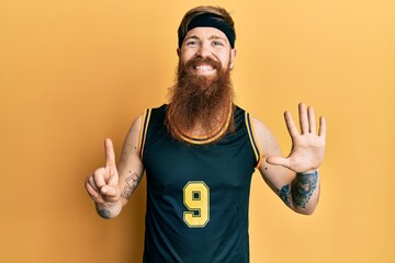 Fototapeta premium Redhead man with long beard wearing basketball uniform showing and pointing up with fingers number six while smiling confident and happy.