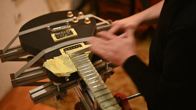 Guitar in repair service shop with a hands of a guitar luthier 