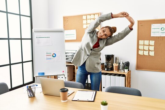 Young woman business worker stretching at office