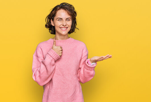 Young hispanic woman wearing casual clothes showing palm hand and doing ok gesture with thumbs up, smiling happy and cheerful