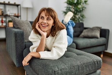 Young caucasian woman smiling confident lying on sofa at home