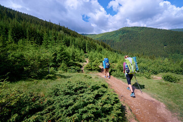 Active lifestyle. Trekking and hiking.Traveling together. Couple of tourists with backpacks in the mountains forest.