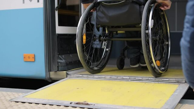 Person with a physical disability enters public transport with an accessible ramp