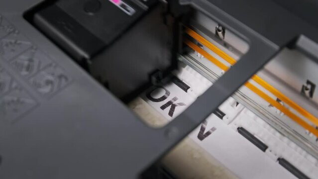NFT token printing. Process of printing a paper document on a jet printer. Multi-colored inscription NFT token on a white sheet of paper is printed by a printer. Concept of creating non-fungible token