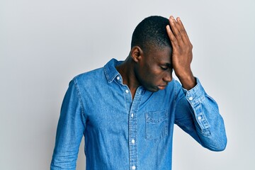 Young african american man wearing casual clothes surprised with hand on head for mistake, remember...