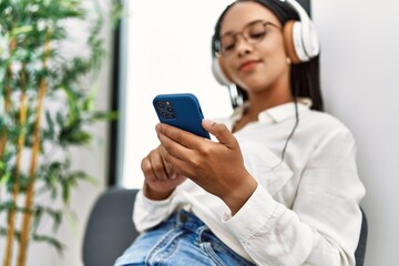 Young african american woman smiling confident listening to music at waiting room