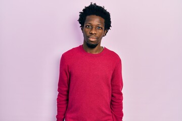 Young african american man wearing casual clothes relaxed with serious expression on face. simple and natural looking at the camera.