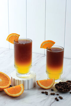 Iced Americano Black Coffee and Layer of Orange and Lemon Juice Decorated with Sliced Orange and Coffee Bean