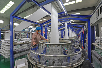Workers work hard on the plastic fiber textile production line, North China