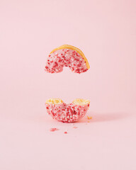 Minimal composition with pink donut cutted in half against pastel pink background. Creative copy...