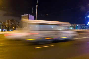 Motion of a blurred minibus on an overpass in the evening in winter.
