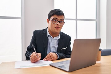 Fototapeta premium Down syndrome man business worker writing on document at office