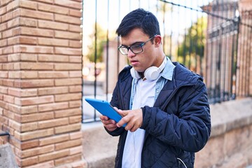 Down syndrome man wearing headphones using touchpad at street