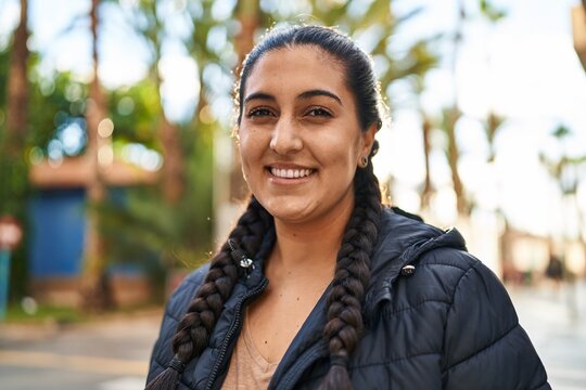 Young hispanic woman smiling confident standing at street